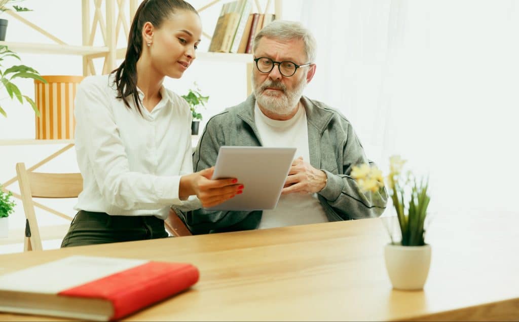 A daughter or granddaughter spends time with the grandfather